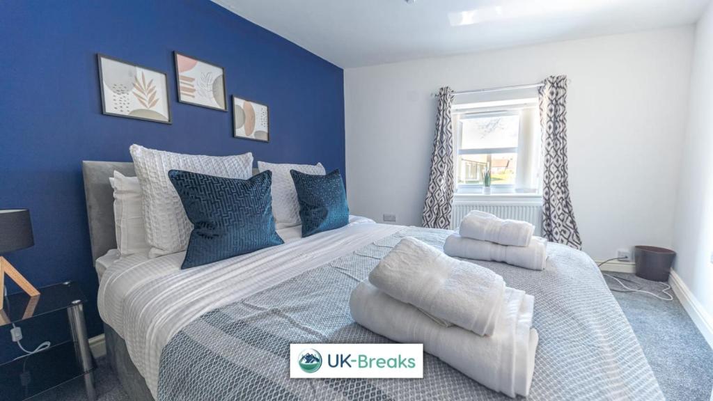 a bedroom with a large bed with blue walls at Pet-friendly holiday home in Egremont