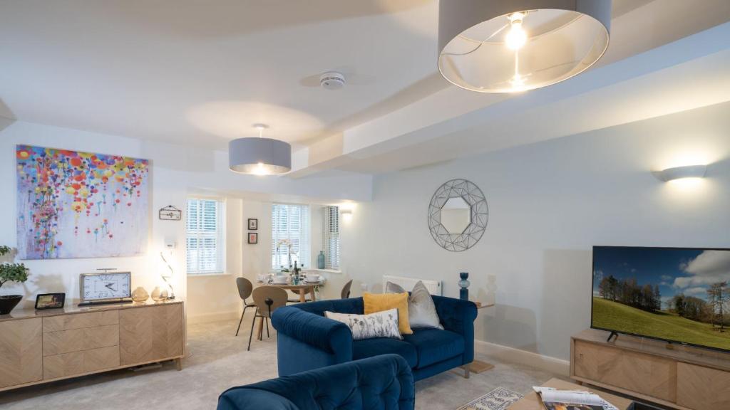 a living room with a blue couch and a tv at Bronte Apartment - Dales - Lakes - Kirkby Lonsdale in Carnforth