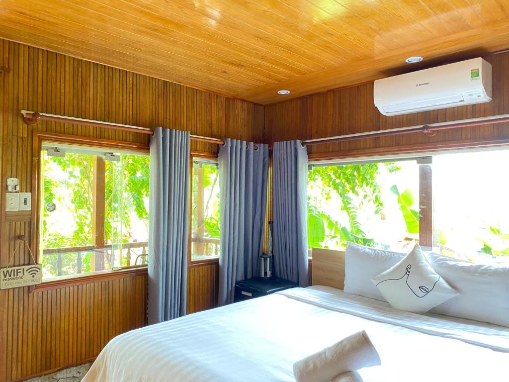 sypialnia z dużym łóżkiem i dużym oknem w obiekcie Kim's Garden w mieście Con Dao