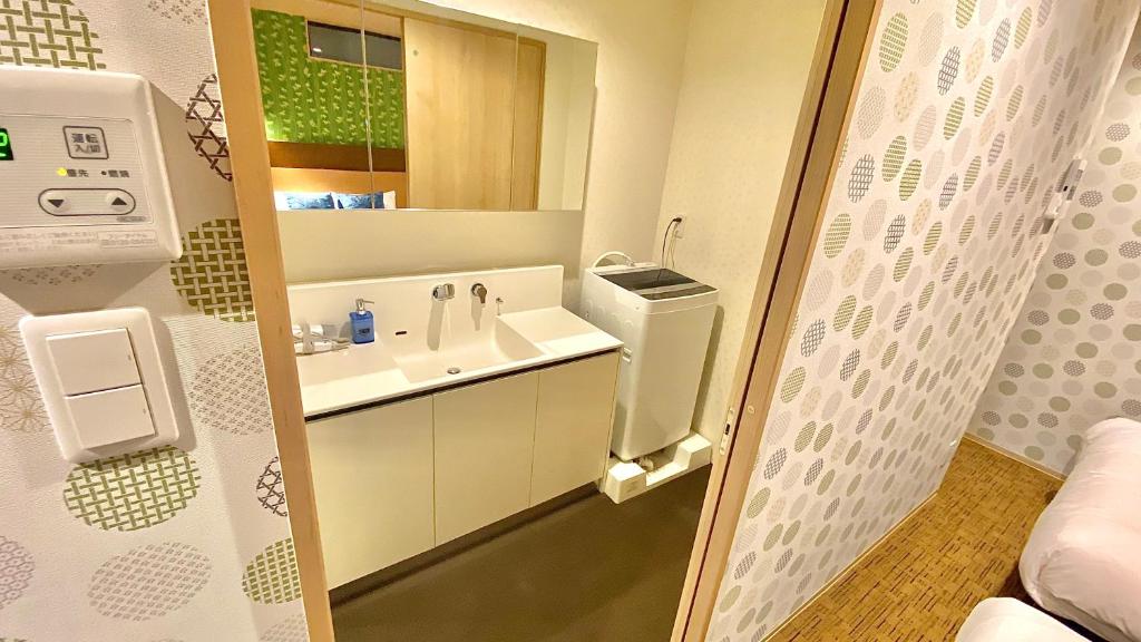a bathroom with a sink and a mirror at One More Heart Fushimi Inari in Momoyama-chō