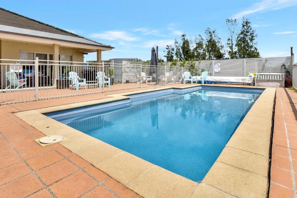 a swimming pool with blue water in a yard at Silver Springs Estate in Rothbury