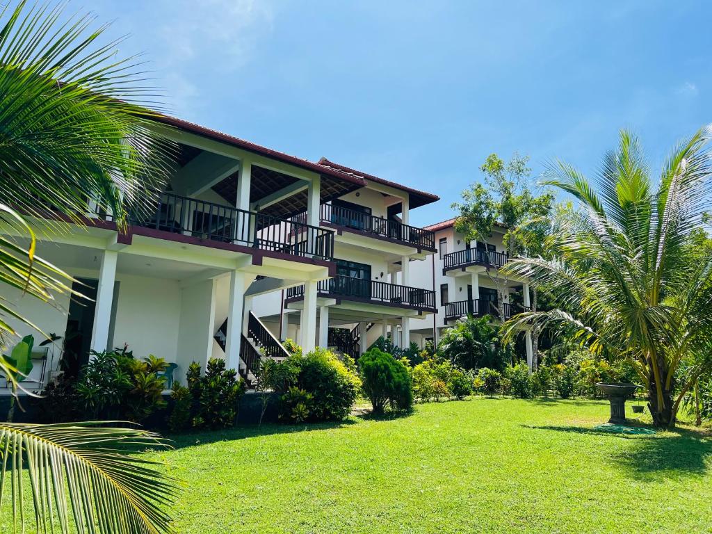 a large building with a lawn in front of it at Ashansa Lagoon Resort in Tangalle