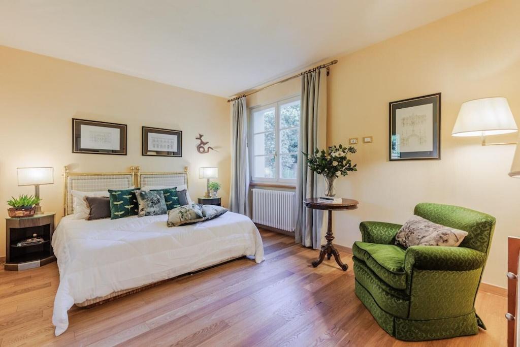 une chambre avec un lit et une chaise dans l'établissement Villa Bassotta, a Charming Cottage, à Lucques 91 autres photos