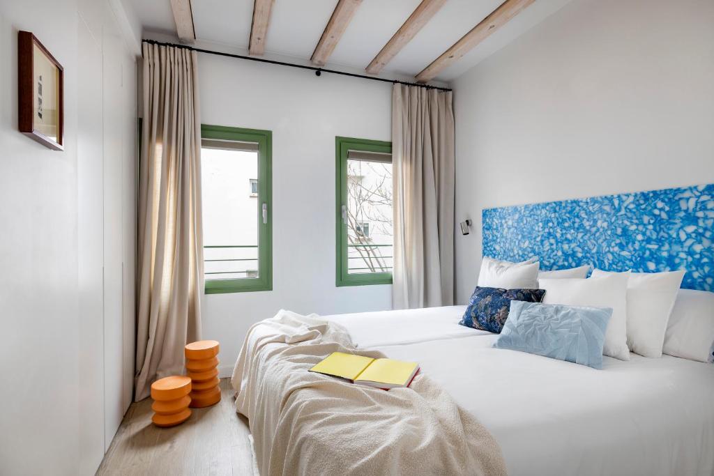 a bedroom with a bed with a book on it at Calatrava - Darya Living in Madrid
