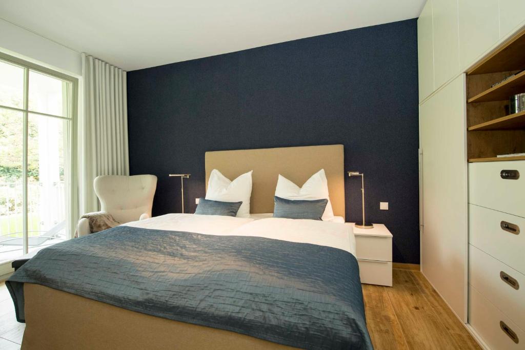 a bedroom with a large bed with blue walls at Villa Pauline Whg. 01 mit Balkon in Göhren