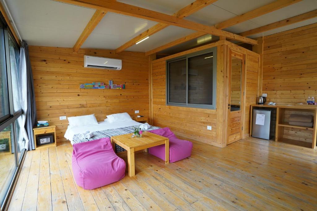 een slaapkamer met een bed en een tafel in een kamer bij Blue Jay Valley in Jezzîne