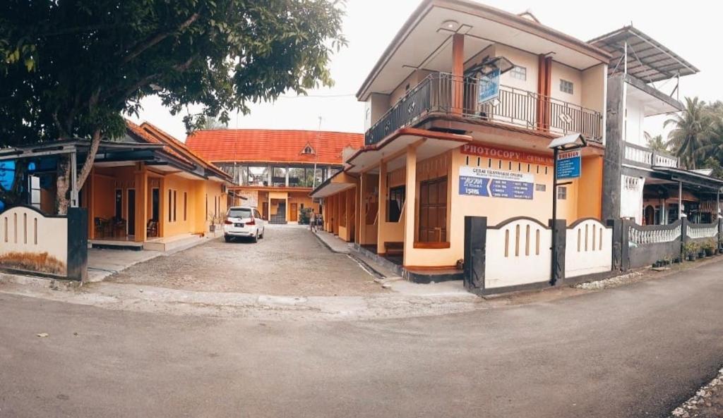 Homestay Putra Sindang Asih Batukaras في Batukaras: سيارة تقف في شارع مجاور للمباني