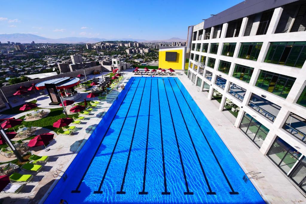 einen Blick über den Pool auf einem Gebäude in der Unterkunft Hills Resort Hotel in Yerevan