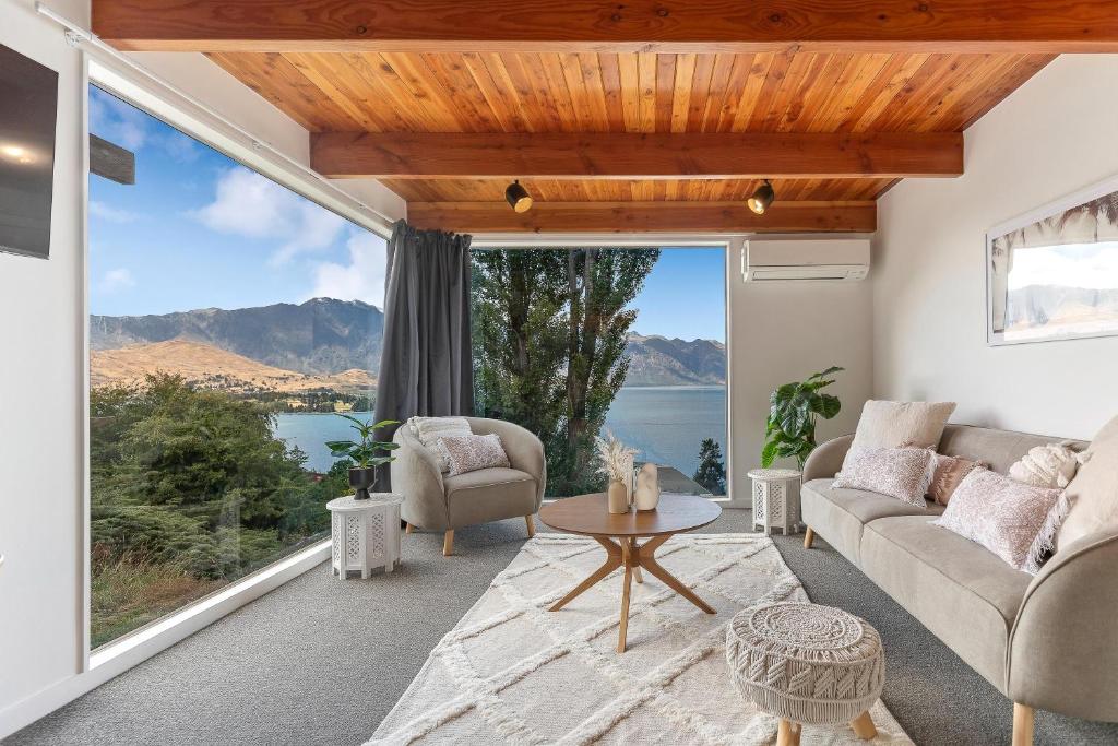 uma sala de estar com vista para a água e as montanhas em Spacious relaxing home em Queenstown