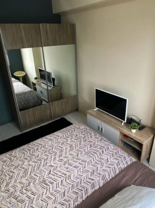 ein Schlafzimmer mit einem Bett und einem großen Spiegel in der Unterkunft AR studio apartmn m square in Bandung