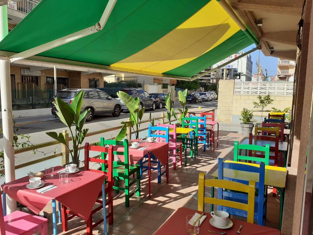 un grupo de mesas con sillas coloridas en una calle en Hotel Clibomar Jamaica, en Gandía