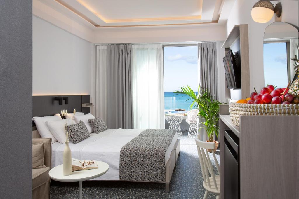 una habitación de hotel con cama y una habitación con vistas en Pearl SeaBreeze Suites, en Rethymno