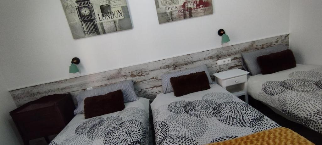 ロスピタレート・デ・リョブレガートにあるApartment Fira Bcn Camp Nouのベッドルーム1室(ベッド2台付)が備わります。壁に2枚の写真が飾られています。
