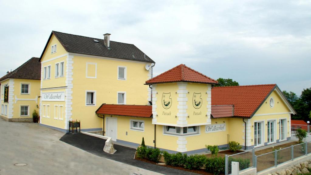 eine Reihe gelber Häuser mit roten Dächern in der Unterkunft Wallseerhof in Wallsee