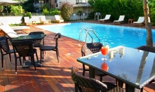 um pátio com uma mesa e cadeiras ao lado de uma piscina em Island Hotel em Istambul