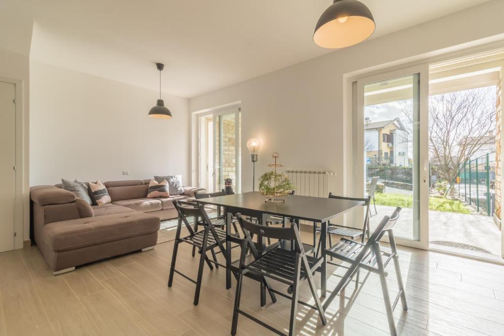 ein Wohnzimmer mit einem Tisch, Stühlen und einem Sofa in der Unterkunft Villa luminosa ed elegante a Sutri in Sutri