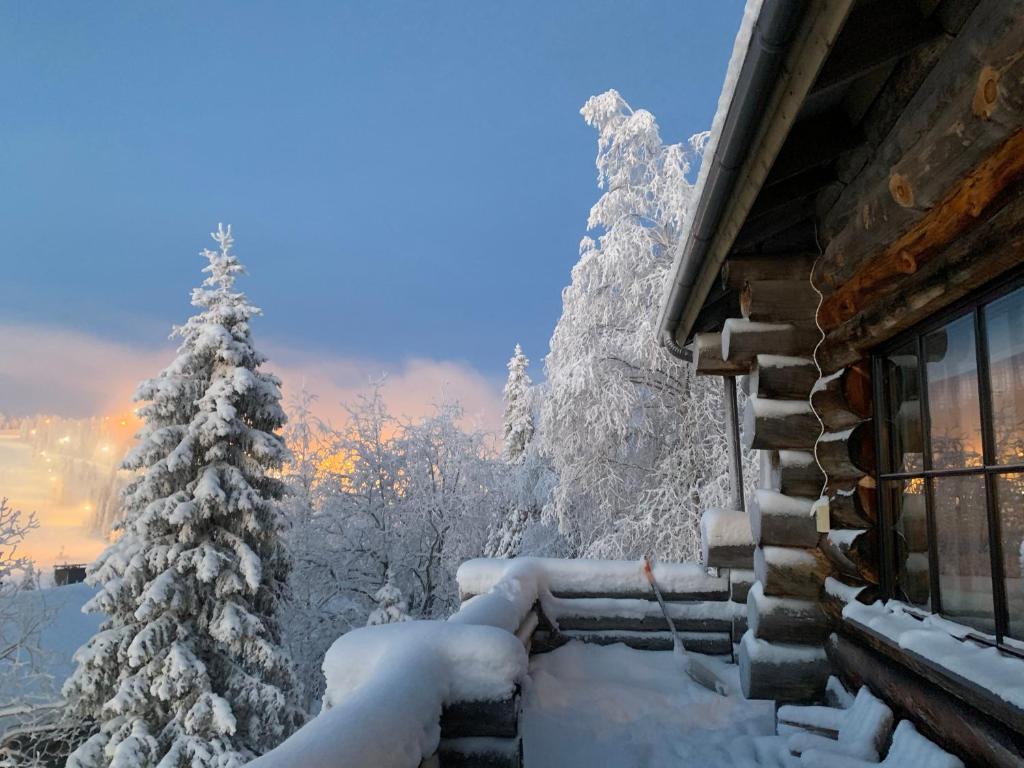 クーサモにあるVilla Sukkaの雪に覆われた家(窓とクリスマスの木付)