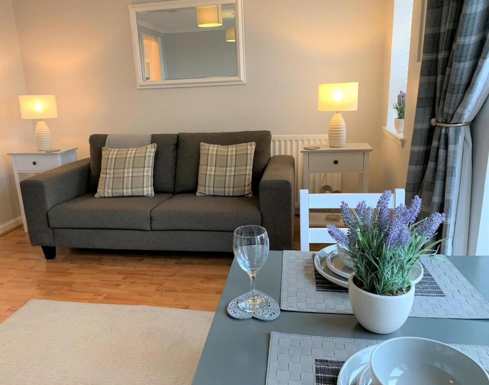 uma sala de estar com um sofá e uma mesa em Kintyre Apartment em Ayr