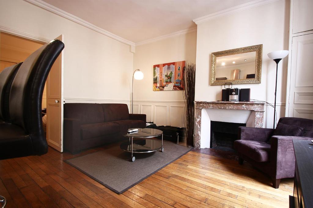 un salon avec un canapé et une cheminée dans l'établissement bridgestreet ST GERMAIN, à Paris