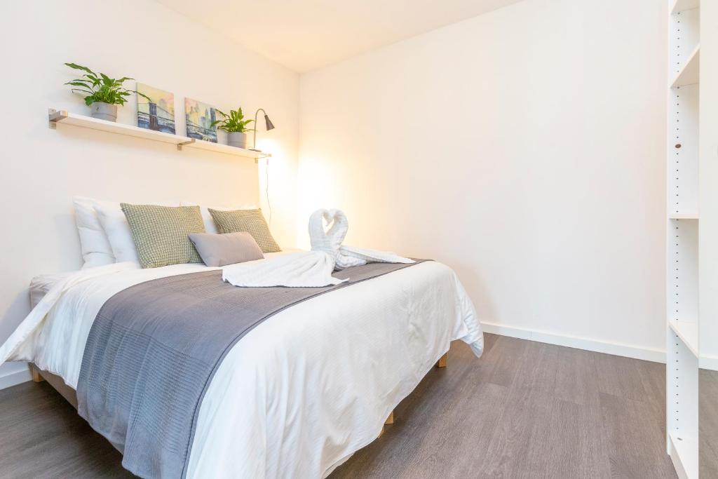 a bedroom with a large bed with white sheets at Newly build Loft city center Delft XL Family apartment in Delft