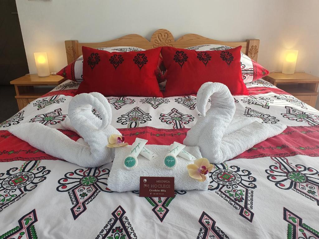łóżko z dwoma łabędzie wykonanymi z ręczników w obiekcie Mrowca Noclegi Pokoje Gościnne w mieście Gronków