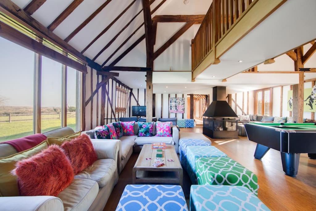 a living room with a couch and a pool table at Luxury, countryside barn conversion with Hot tub in Kent