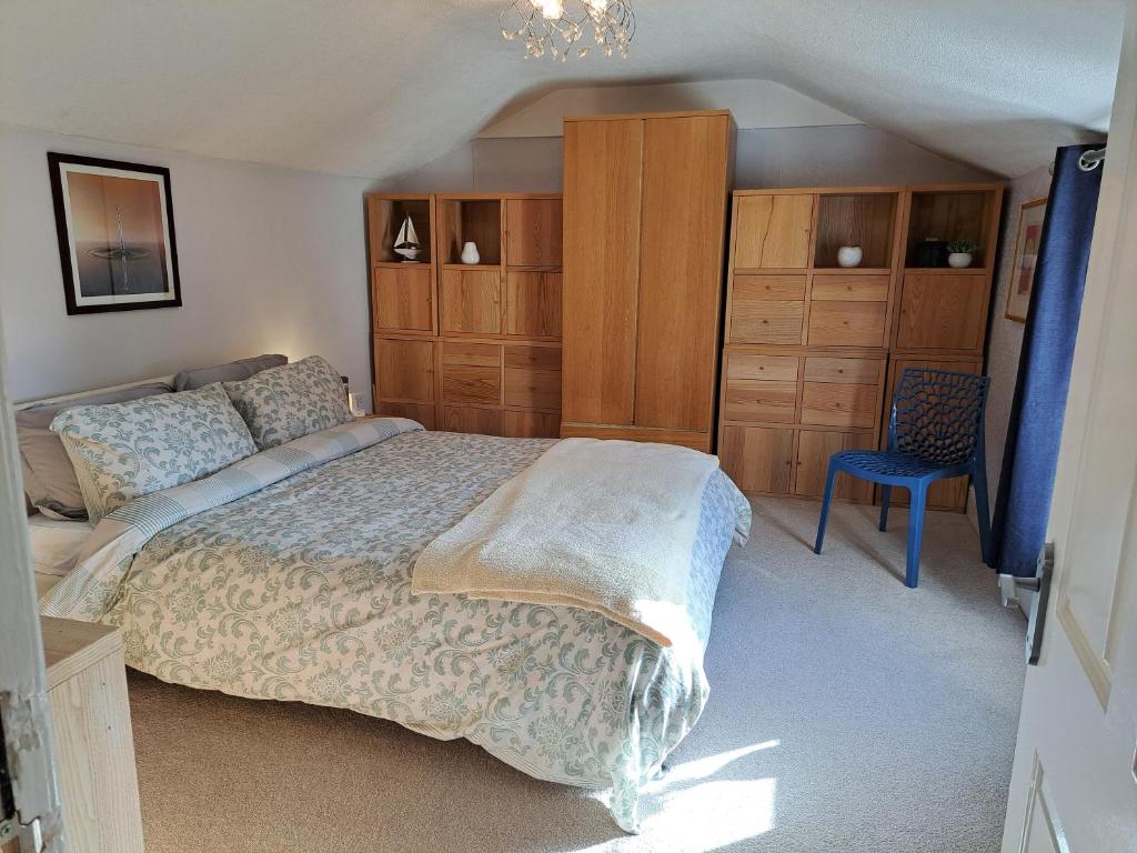 um quarto com uma cama, armários de madeira e uma cadeira em Executive Central Apartment - AR em Southport