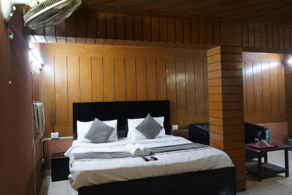 een slaapkamer met een groot bed en houten wanden bij Hotel Quadis - Noida sec 15 in Noida