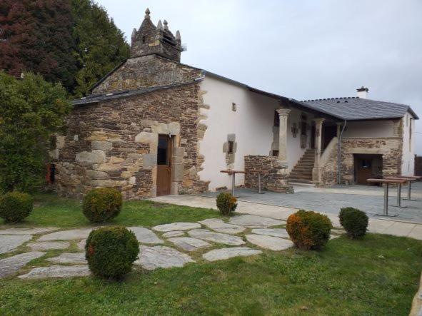 un antiguo edificio de piedra con un camino de piedra delante de él en CASA DE ALDEA VAL DOS SOÑOS en Lugo
