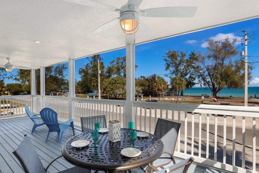 a dining table on a deck with a view of the ocean at Coquina Cottage B home in Anna Maria