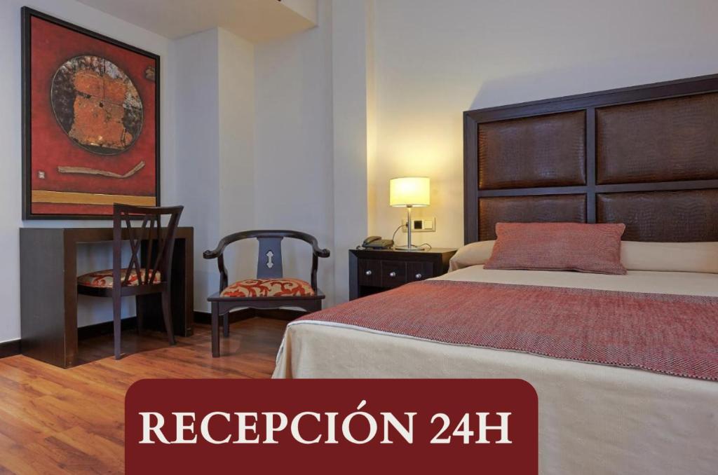 a bedroom with a bed and a desk and a chair at Hotel Las Cabañas in Peñaranda de Bracamonte