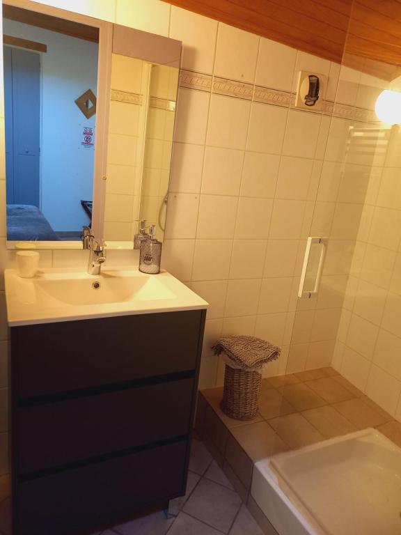 W łazience znajduje się umywalka, lustro i wanna. w obiekcie CHAMBRES D'HOTES L'ANTONIN w mieście Saint-Antoine