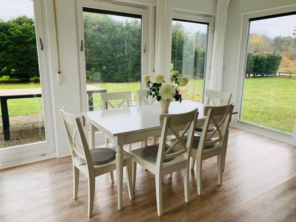 un comedor blanco con una mesa y sillas blancas en Sandhuegel-5-EG, en Nebel