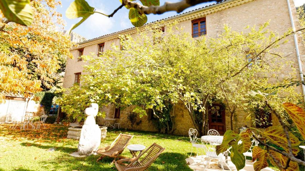 een tuin met twee stoelen en een gebouw bij La Bastide du Paradou in Moustiers-Sainte-Marie