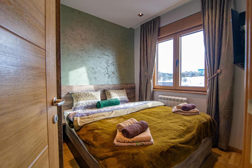 um quarto com uma cama com toalhas em Luxury Kalman Centar Apartman em Zlatibor