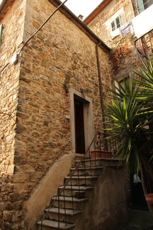 a brick building with stairs leading up to a door at Trilocale nel centro storico in Montemerano