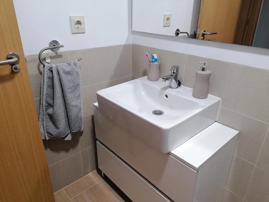 łazienka z białą umywalką i lustrem w obiekcie Agradable casa adosada con piscina w mieście Zahara de los Atunes