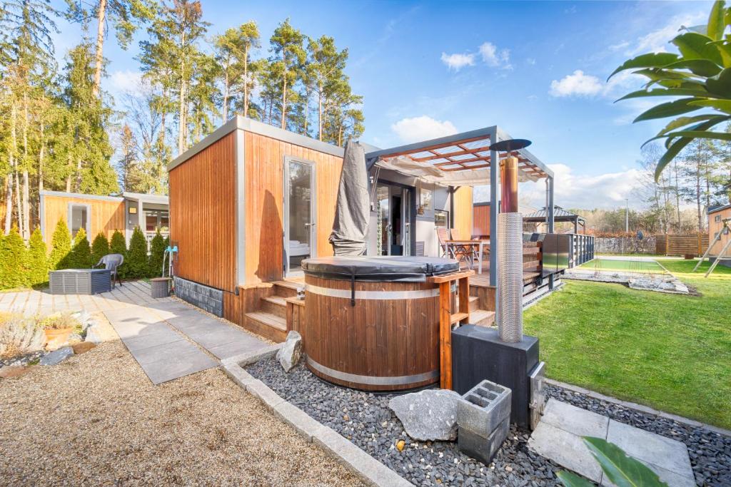 Cabaña de madera con bañera de hidromasaje en un patio en Mobilheim am Murner See - private Sauna + privater Badezuber, en Wackersdorf
