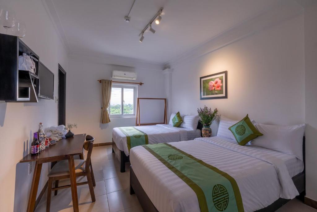 Giường trong phòng chung tại Charming Riverside Hotel