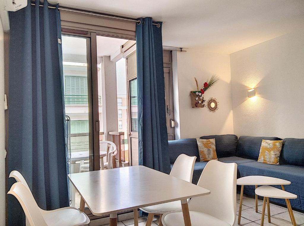 ein Wohnzimmer mit einem Sofa, einem Tisch und Stühlen in der Unterkunft Résidence Graziella Studio 301 in Juan-les-Pins