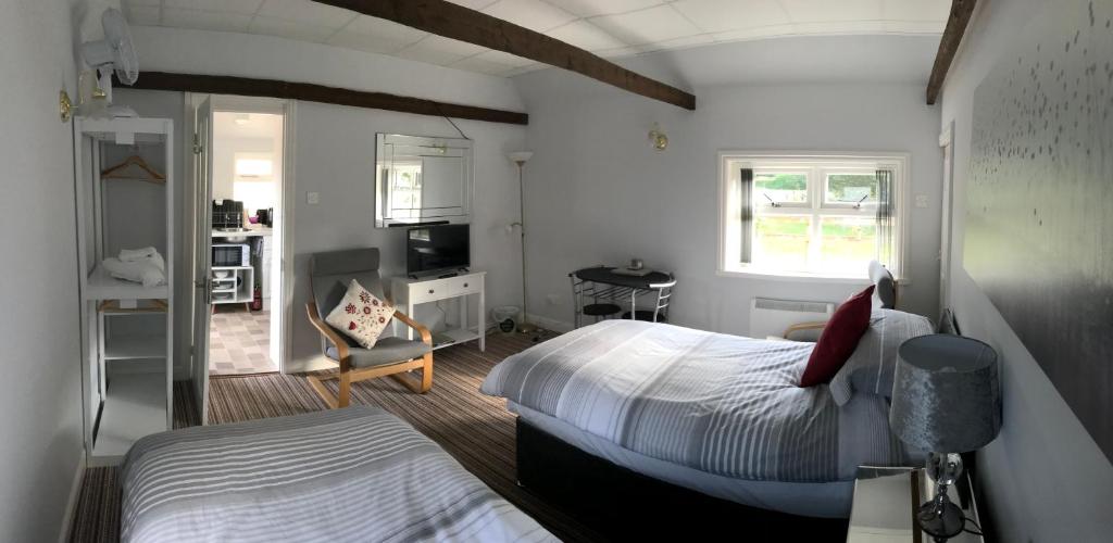 a bedroom with two beds and a desk with a chair at The Annex in Malton