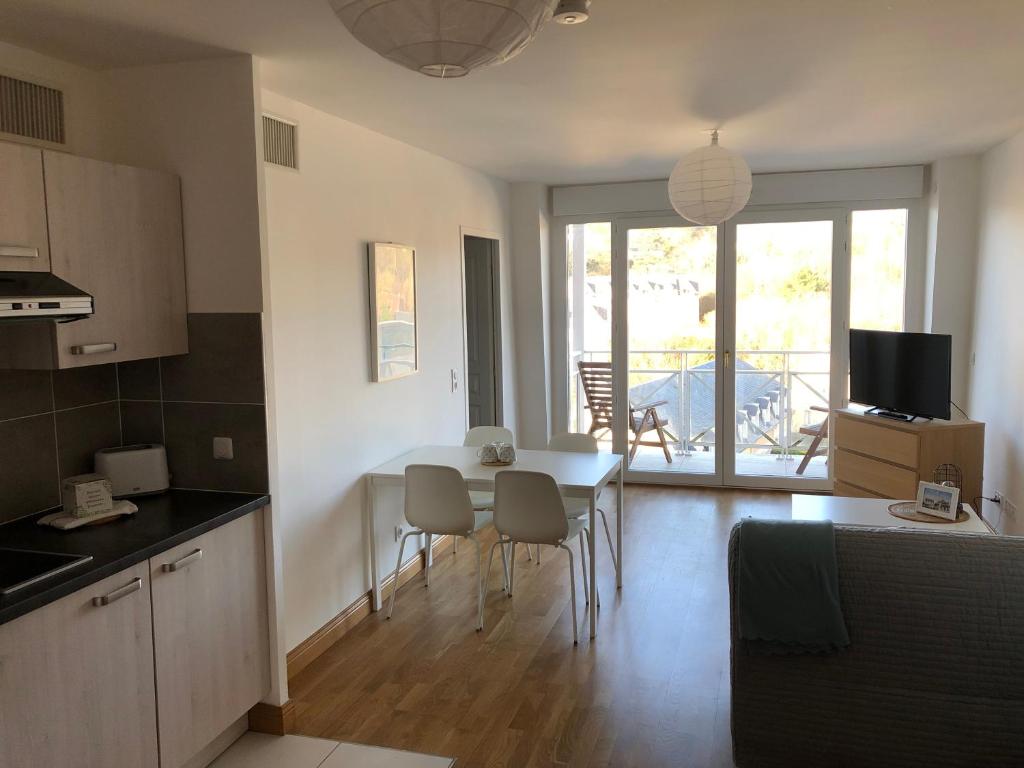 a kitchen and living room with a table and chairs at Villa Médicis Trouville-sur-mer in Trouville-sur-Mer