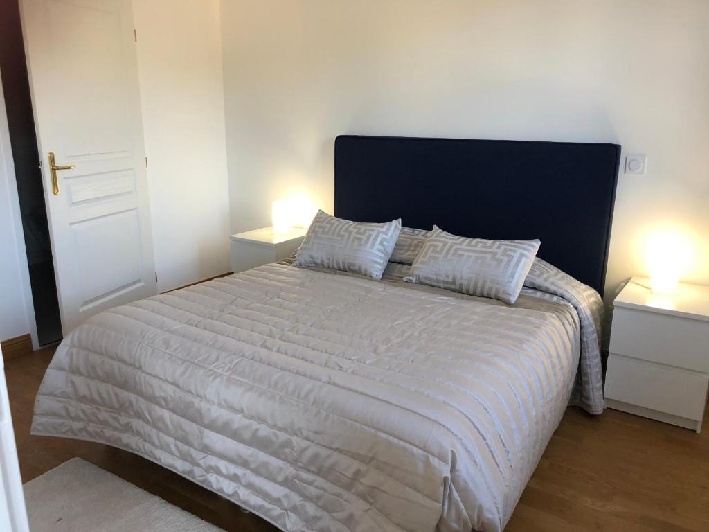 a bedroom with a large white bed with two lamps at Villa Médicis Trouville-sur-mer in Trouville-sur-Mer