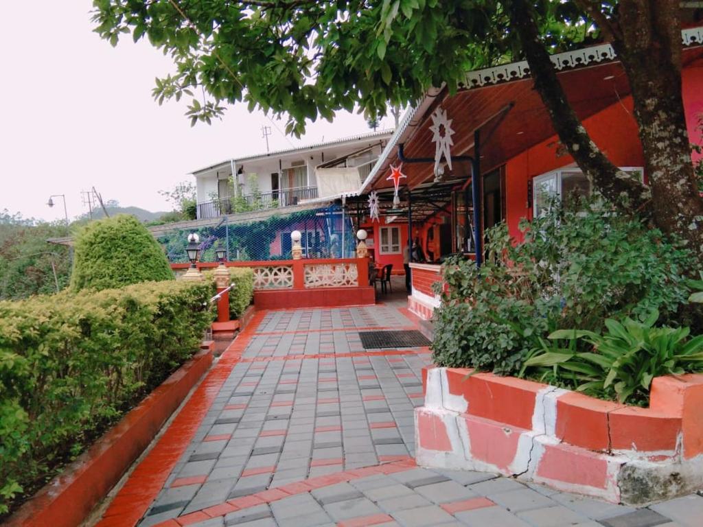 una passerella di fronte a un edificio con un albero di Ivy paradise cottage (IV cottage) a Munnar