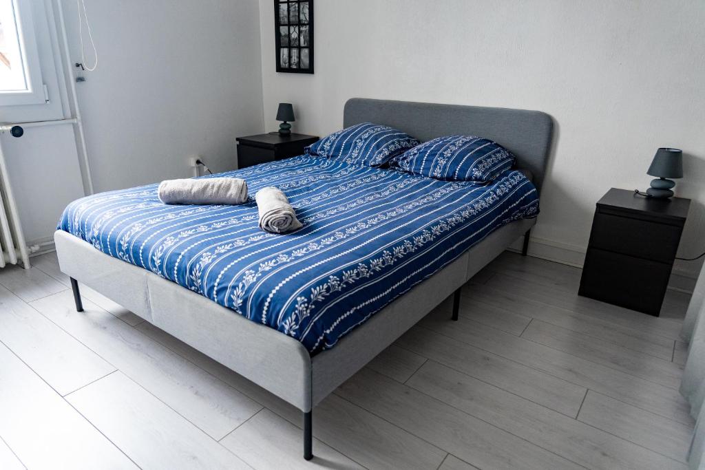1 cama con edredón azul y 2 almohadas en Maison au pied du château, en Châteaudun