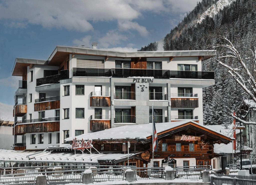 un hotel en las montañas con nieve en el suelo en Hotel Piz Buin, en Ischgl