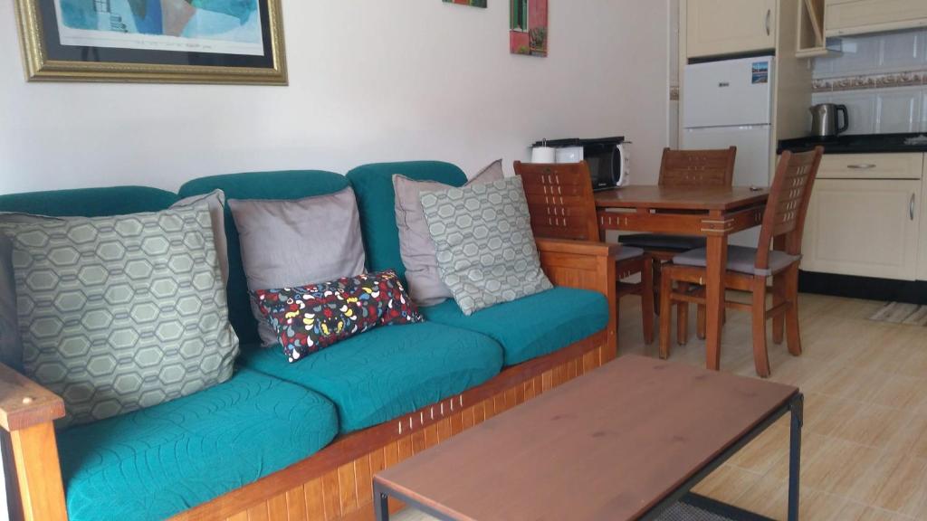 een woonkamer met een blauwe bank en een tafel bij Apartment in the City Center near to the beach in Puerto del Carmen