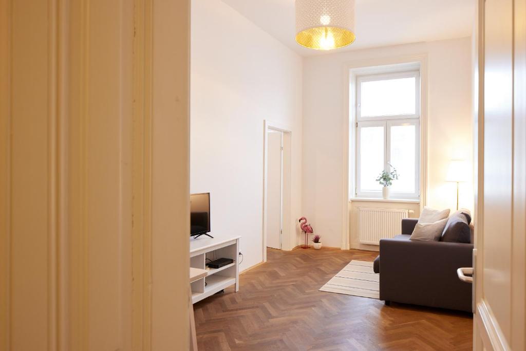 ein Wohnzimmer mit einem Sofa und einem TV in der Unterkunft Self-Check-In & Perfect Metro Connection I in Wien