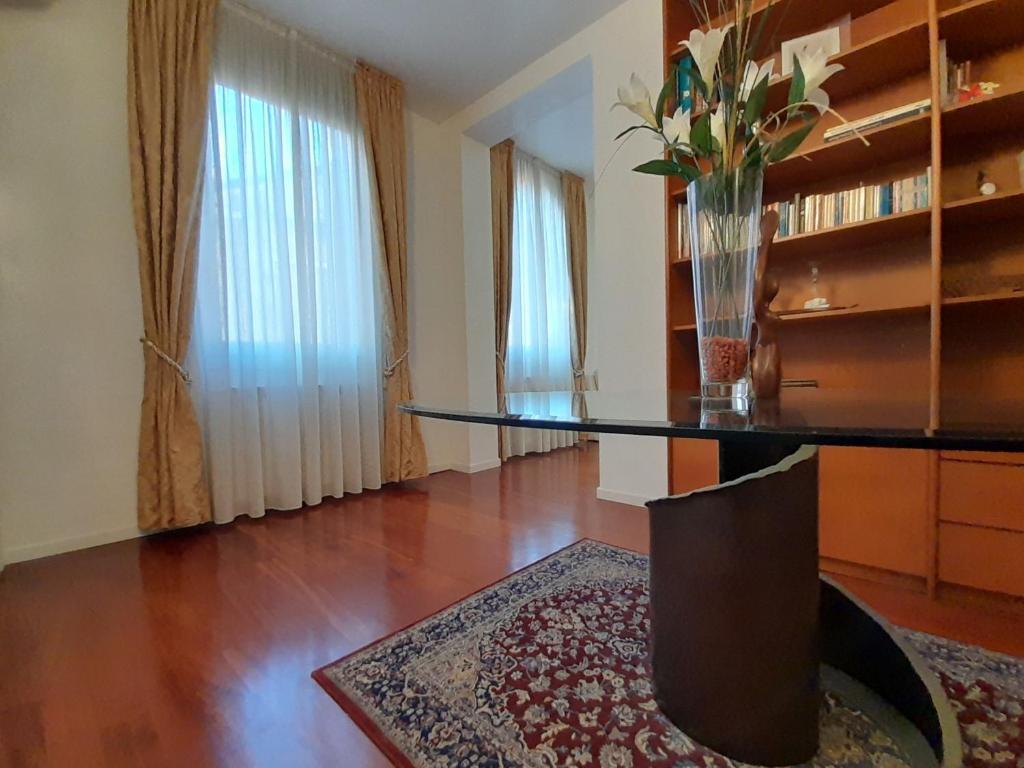 a living room with a glass table and a vase of flowers at San Marco2 Apartment in Venice