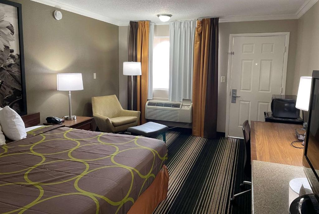 a hotel room with a bed and a desk and chair at Super 8 by Wyndham Junction City in Junction City